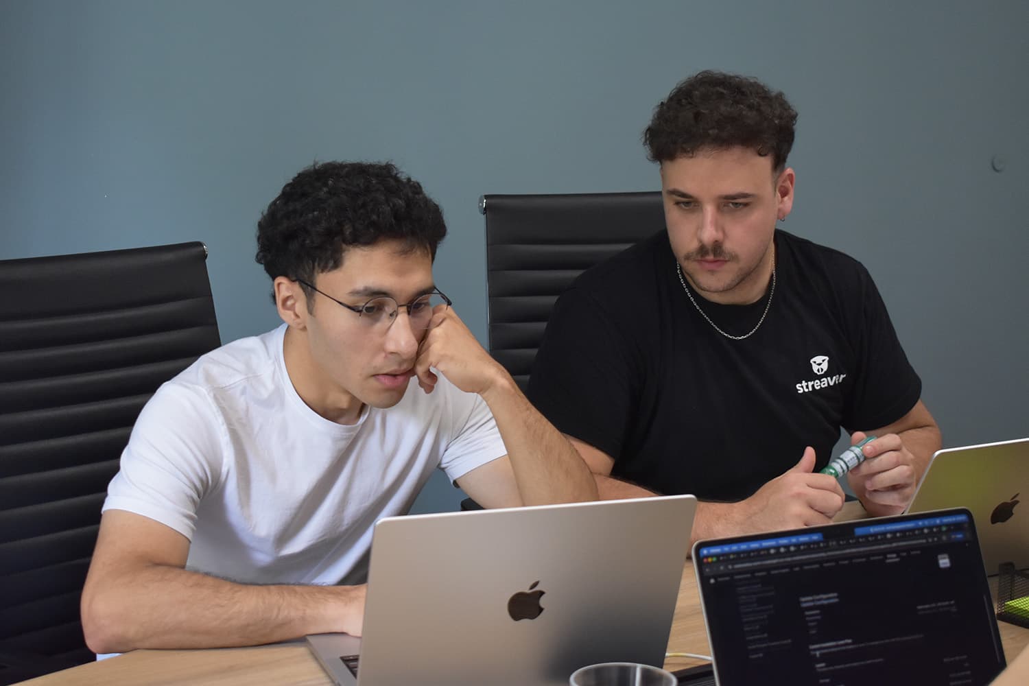 Two Streaver teammates pairing on a laptop during an AI strategy session